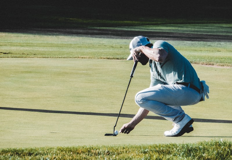 Un joueur regardant sa ligne de putt avant de se lancer 